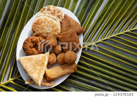 Authentic Sri Lankan different street food, short eats. Vegetable roti, coconut roti, cutlets, mutton rolls on white plate. View from above. Copy space. 124376103