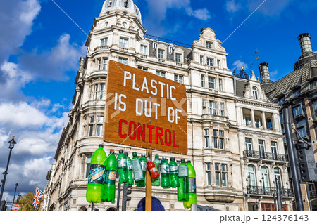 Activist holds anti plastic pollution sign with bottles in urban street protest 124376143