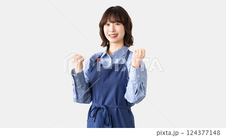 ガッツポーズをするエプロン姿の女性 124377148