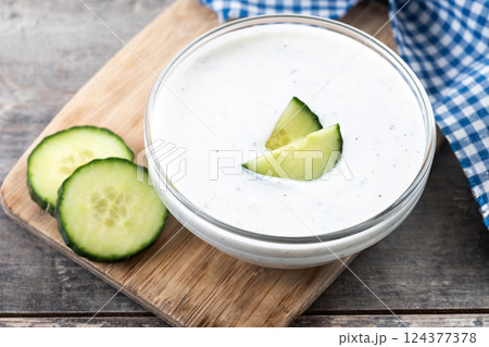 Greek Tzatziki sauce in bowl on wooden table 124377378