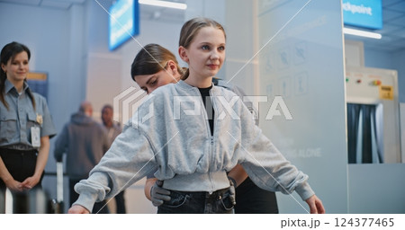 Airport Terminal: Female TSA Officer Checks Girl For Boarding Flight Airport Terminal: Female TSA Officer Checks Girl For Boarding Flight 124377465