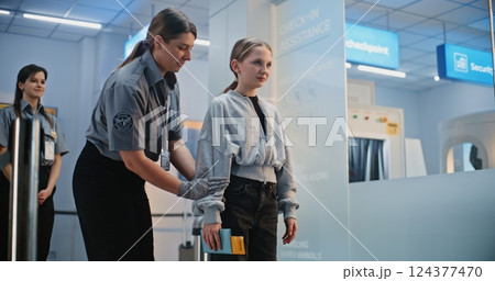 Female Officer Inspects Teenage Girl For Boarding Plane Flight. Young Tourist Going on Trip Female Officer Inspects Teenage Girl For Boarding Plane Flight. Young Tourist Going on Trip 124377470