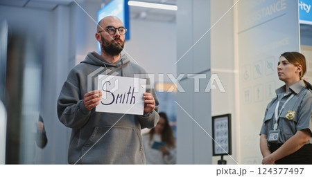 Airport Greeter Holding Name Sign, Waiting for Passengers From Plane Flight Airport Greeter Holding Name Sign, Waiting for Passengers From Plane Flight 124377497