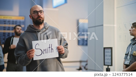 Transportation Service in Airport: Airport Greeter Holding Greeting Sign, Waiting for Passengers 124377514