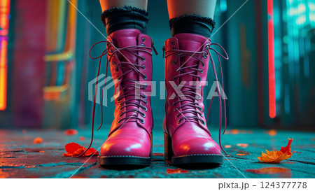 Woman wearing pink boots standing on wet pavement at night with neon lights 124377778
