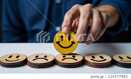 Businessman choosing positive feedback, placing yellow smiley face on top of others 124377965