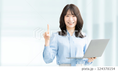 ノートパソコンを持って案内をする笑顔の女性・ビジネスウーマン 124378154