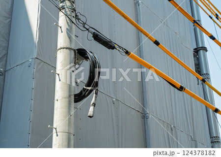 建設現場と電柱に巻いた黒いケーブル 124378182