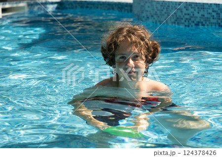 Teenager swims in swimming pool in summer. Outdoors. Summer vacation at sunny day 124378426