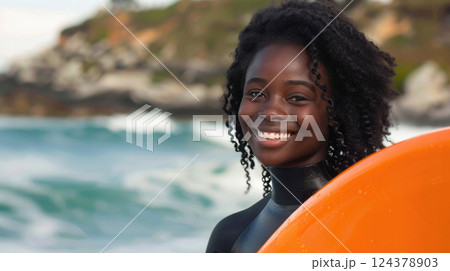 portrait of a young smiling beautiful African American female surfer with long curly hair, bright red orange surfboard, beach vacation by the ocean, sunny day portrait of a young smiling beautiful African American female surfer with long curly hair, bright red orange surfboard, beach vacation by the ocean, sunny day 124378903
