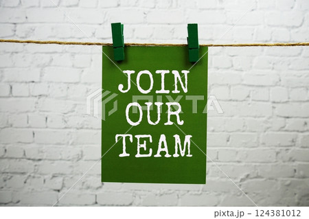 Join Our Team text on paper card hanging with rope on white brick background 124381012