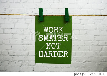 Work smater not harder text on paper card hanging with rope on white brick background 124381014