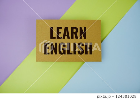 Learn English text written on paper top view on purple green and blue geometric background Learn English text written on paper top view on purple green and blue geometric background 124381029