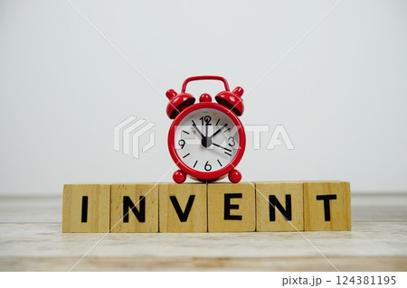 Time to Invent with wooden blocks alphabet letters and alarm clock on wooden background 124381195