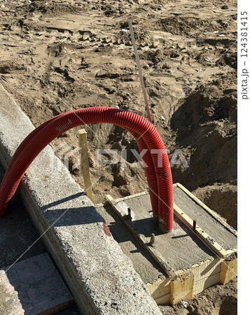 Construction Site with Red Corrugated Electrical Conduit  124381415