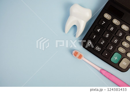 Toothbrush and Tooth with calculator top view on blue background, Dental money and dentist treatment costs 124381433