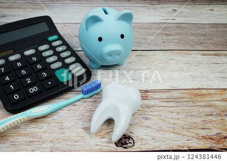 Toothbrush dental hygiene concept with calculator and piggy saving on wooden background, Dental money and dentist treatment costs 124381446