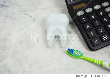 Toothbrush and Tooth with calculator top view on marble background, Dental money and dentist treatment costs 124381450