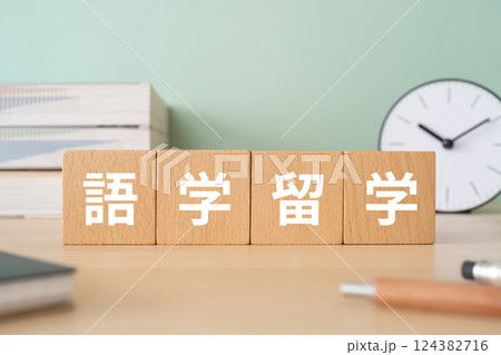 語学留学の文字が入ったブロックが置かれたデスク 124382716