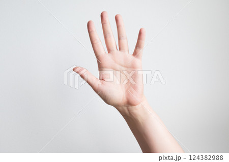 Caucasian adult hand raised against white background with open palm gesture 124382988