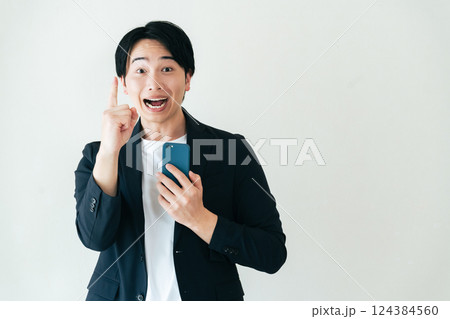 スマホを持って笑顔で話すビジネスマン 124384560