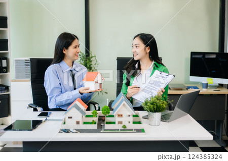 balancing the property sector The real estate agent is explaining the house style to see the house design balancing the property sector The real estate agent is explaining the house style to see the house design 124385324
