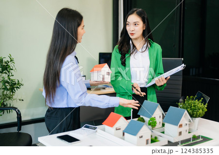 balancing the property sector The real estate agent is explaining the house style to see the house design 124385335