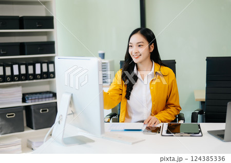 Business woman using tablet and laptop for doing math finance on an office desk, 124385336