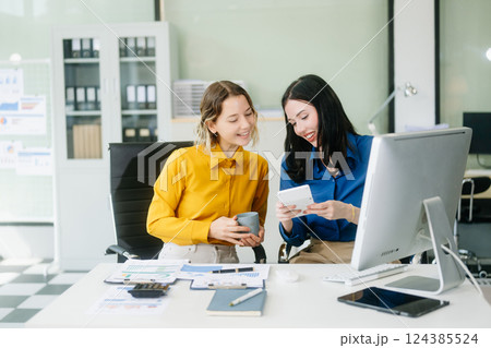 Two business workers talking on the smartphone and using laptop at the office. Two business workers talking on the smartphone and using laptop at the office. 124385524