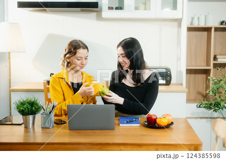 Modern couple collaborating over coffee in a cozy kitchen setting with a laptop, notebook, and breakfast. Modern couple collaborating over coffee in a cozy kitchen setting with a laptop, notebook, and breakfast. 124385598