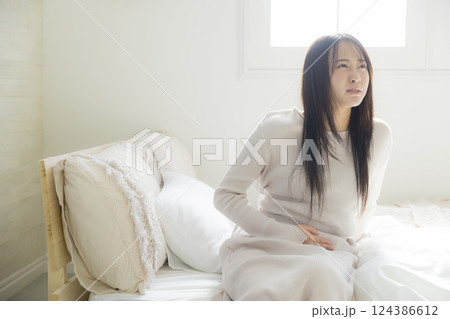 ベッドで体調不良の女性 124386612