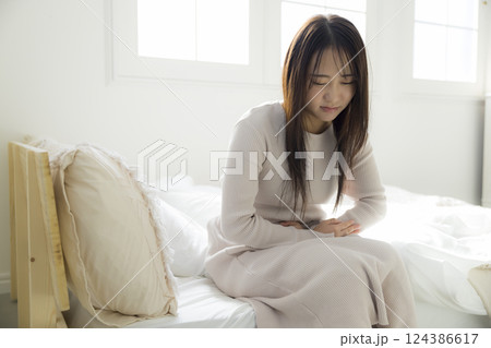 ベッドで体調不良の女性 124386617