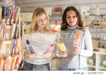 Girl friends client chooses aroma sticks, inhales fragrance 124387753