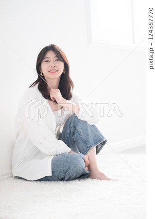 逆光の中イヤリングをしたお洒落な女性ポートレート全身	 124387770