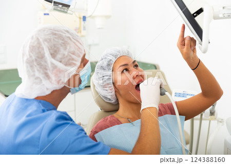 Dentist examining patient teeth with camera 124388160