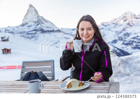 Woman enjoying mulled wine and apple strudel in winter day while traveling in Swiss Alps Woman enjoying mulled wine and apple strudel in winter day while traveling in Swiss Alps 124388373