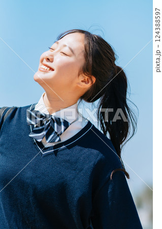 爽やかな青空の下紫外線を浴びる女子高生 124388597