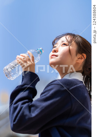 爽やかな日に屋外で水分補給をする女子高生 爽やかな日に屋外で水分補給をする女子高生 124388604