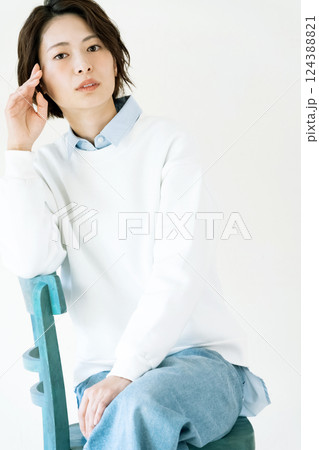 壁際で座る女性のポートレート 124388821