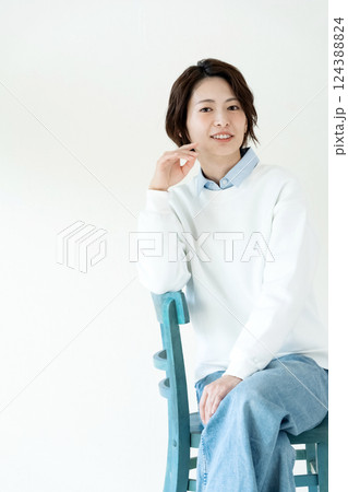 壁際で座る女性のポートレート 124388824