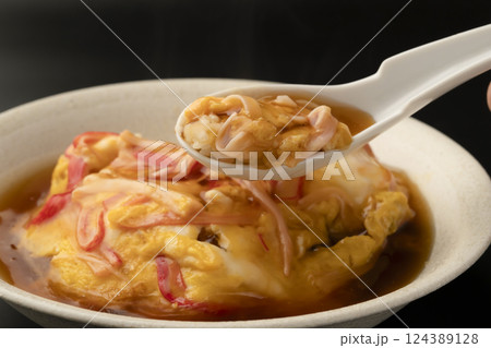 湯気の立った熱々の天津飯をレンゲで持ち上げる 124389128