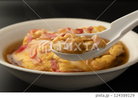 湯気の立った熱々の天津飯をレンゲで持ち上げる 湯気の立った熱々の天津飯をレンゲで持ち上げる 124389129