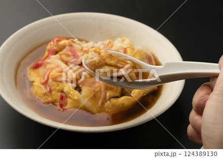湯気の立った熱々の天津飯をレンゲで持ち上げる 124389130