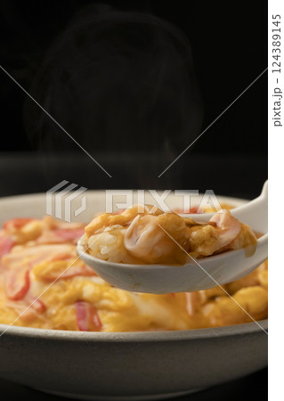 湯気の立った熱々の天津飯をレンゲで持ち上げる 124389145