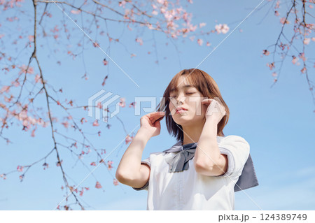 青空と桜の下の女子高生 124389749