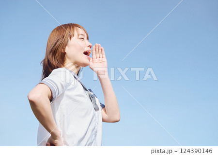 青空の下で呼びかける女子高生 124390146