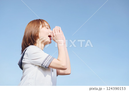 青空の下で呼びかける女子高生 124390153