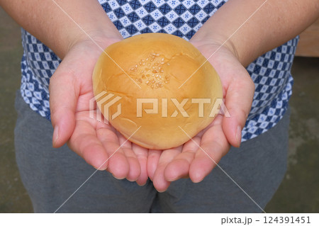 Female hand holding a testy bun , bakery food. 124391451