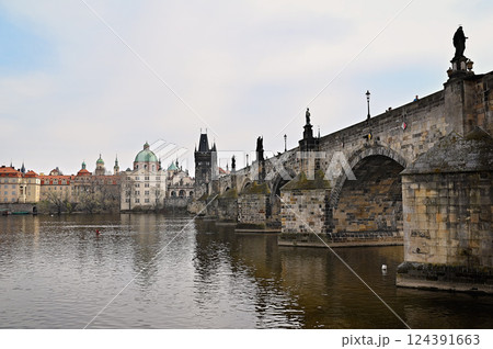 Charles bridge crossing vltava river in Prague with cloudy sky 124391663