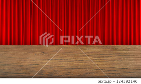 An empty wooden table is set against a red curtain background. An empty wooden table is set against a red curtain background. 124392140